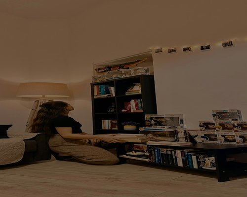 Person adjusting desk lamp for better lighting in a cozy room