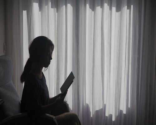 Cozy reading corner by a window with sheer curtains
